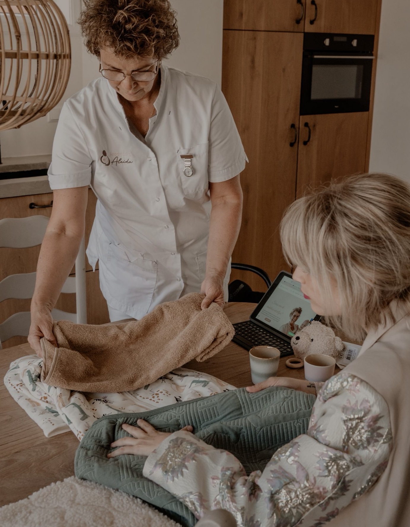 Minke bespreekt babyspullen met een ouder aan tafel