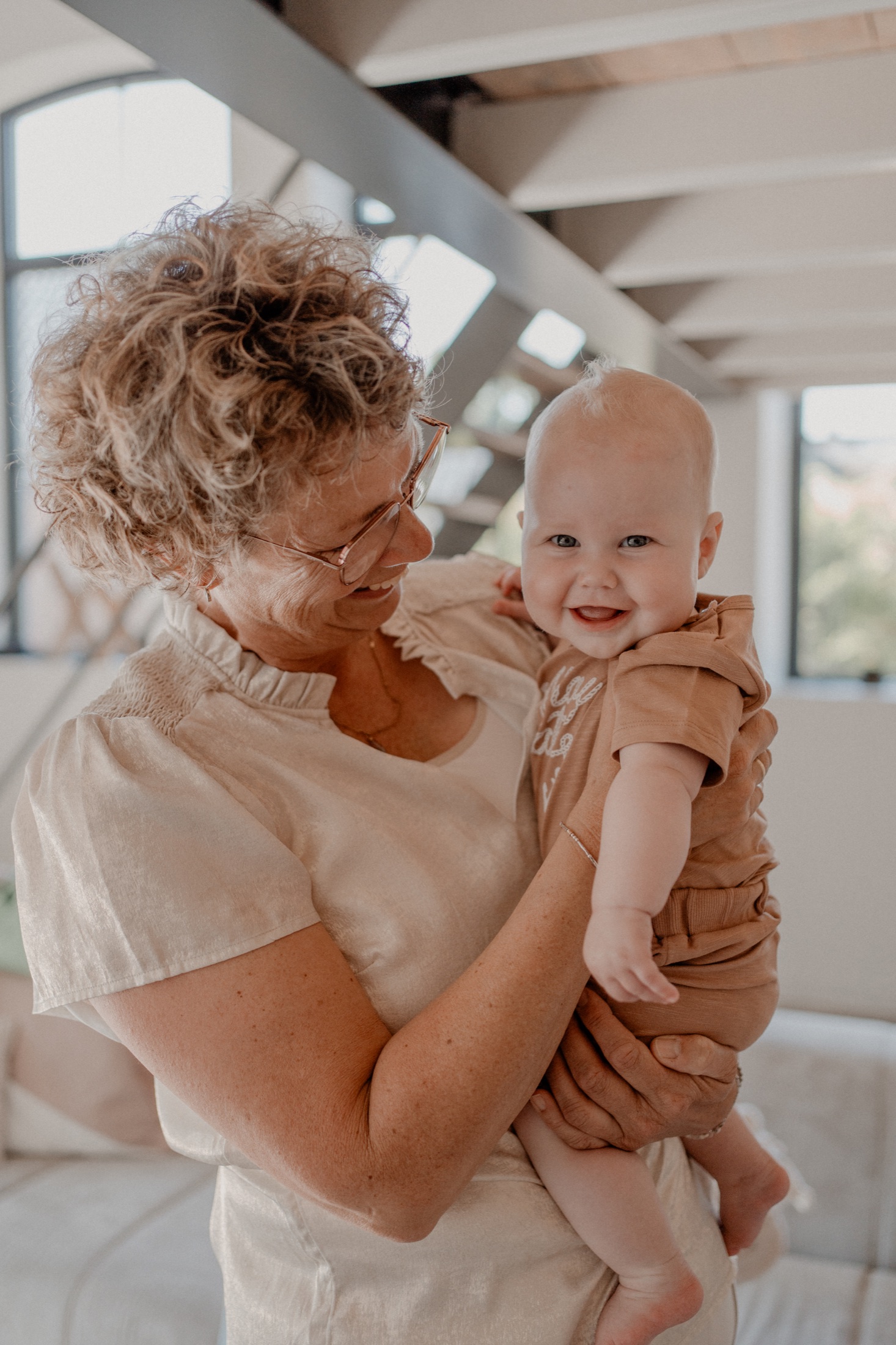 Vrouw kijkt liefdevol naar een lachende baby tijdens de babyvoorbereiding